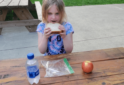 Young lady eating a sandwich, holding it with both hands